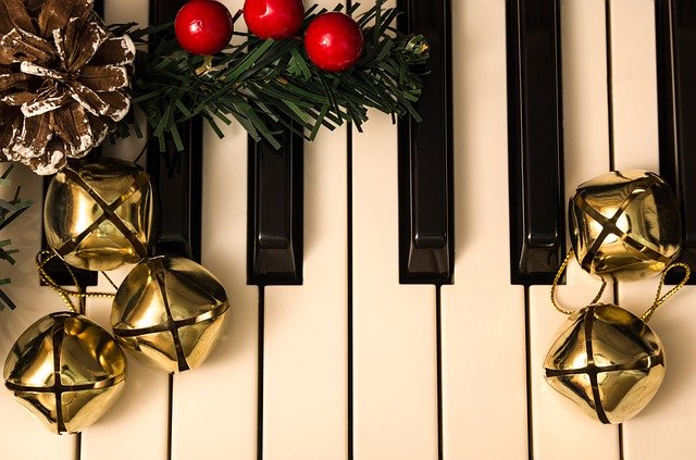 Piano keys, Christmas bells, and greenery with berries 